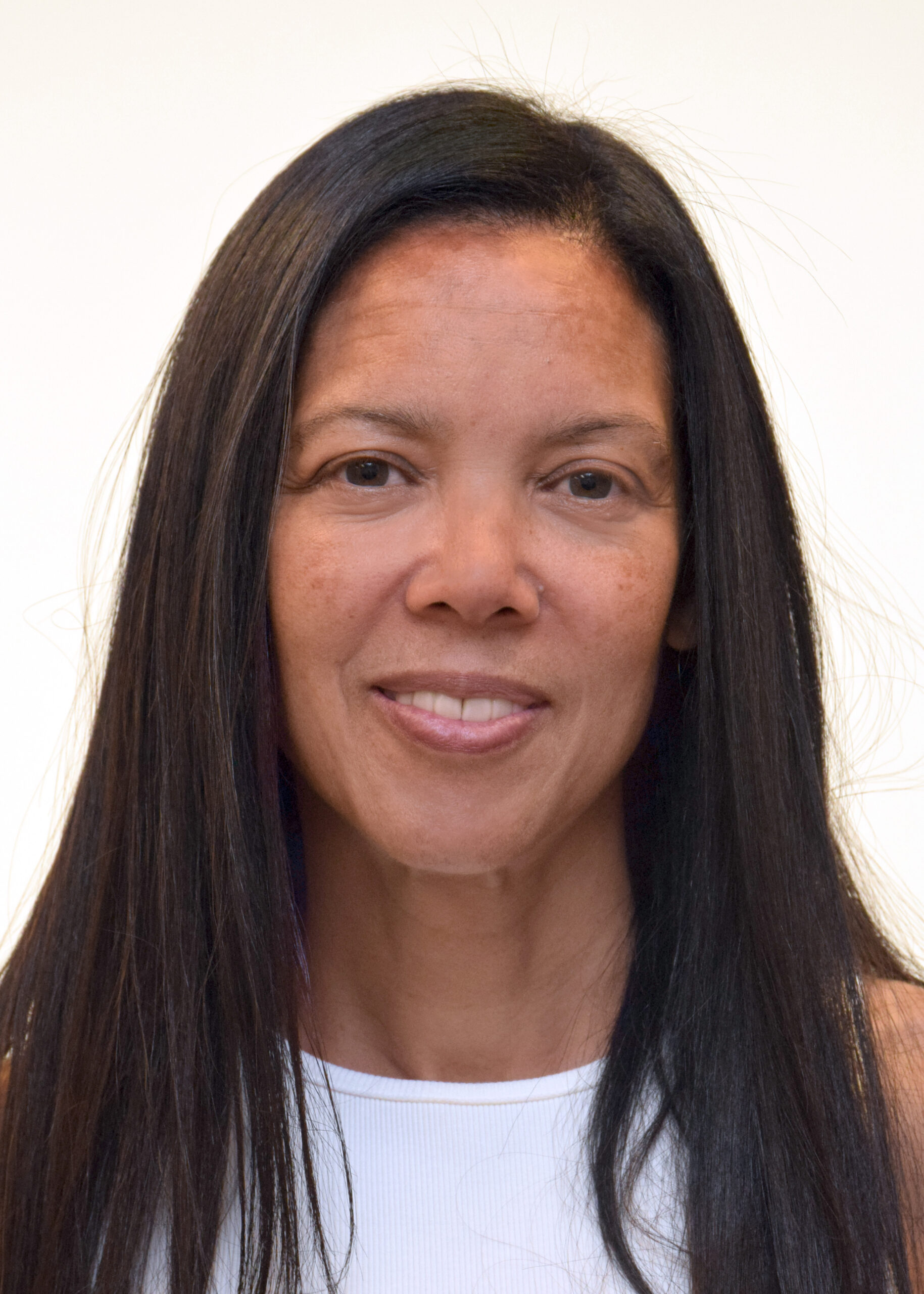 Headshot of a woman with long dark hair against a white backdrop
