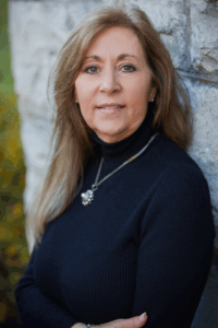 A headshot of a woman wearing a black turtle neck.