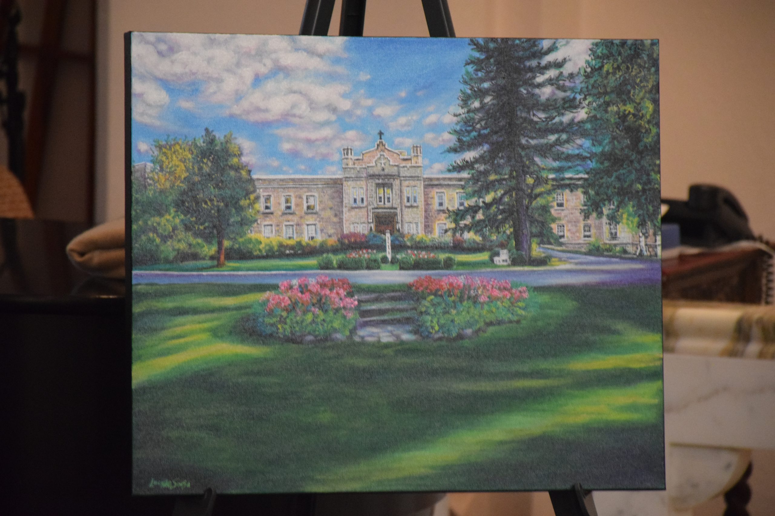 An image of an old limestone building, with green grass in front and blue sky in the background.