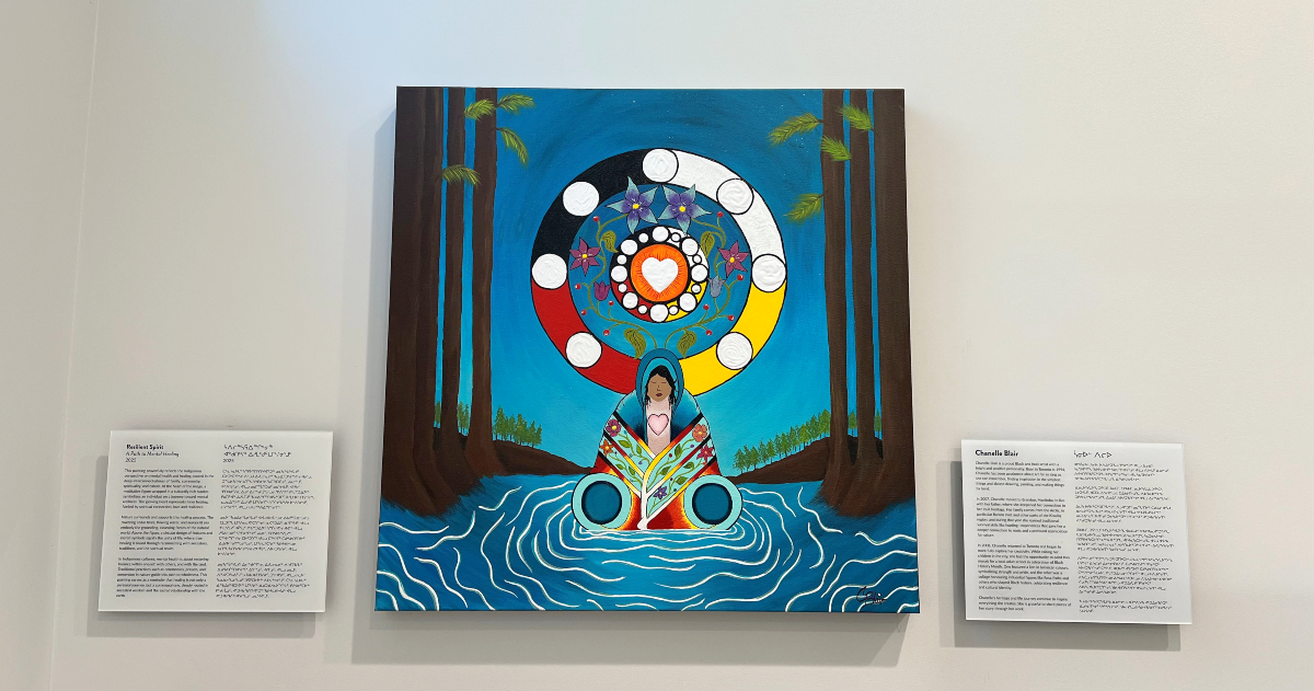 An Indigenous painting with a woman at the centre, sitting in a river, surrounded by trees, with a medicine wheel in the background.