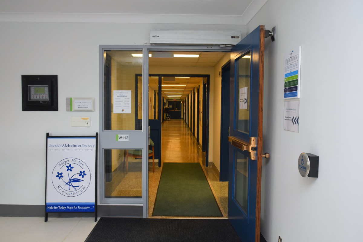An open door leading to a long hallway.